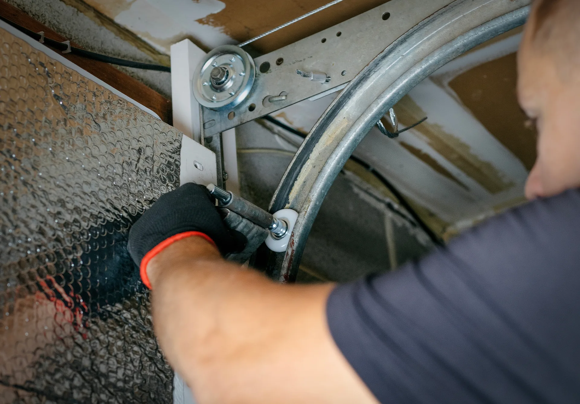 Hands installing tiles on a commercial wall