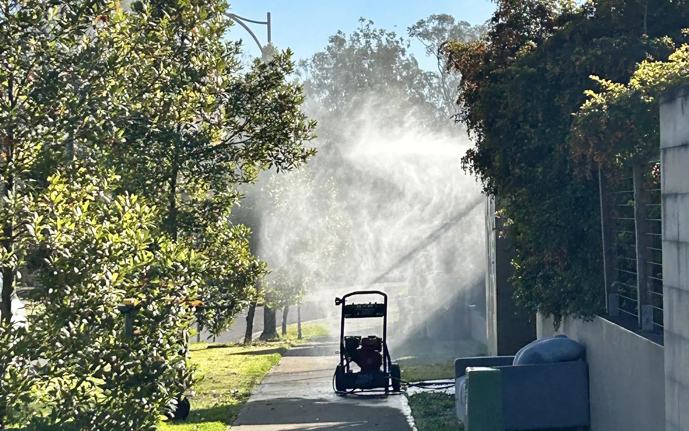 Pressure washing equipment cleaning a hard outdoor surface
